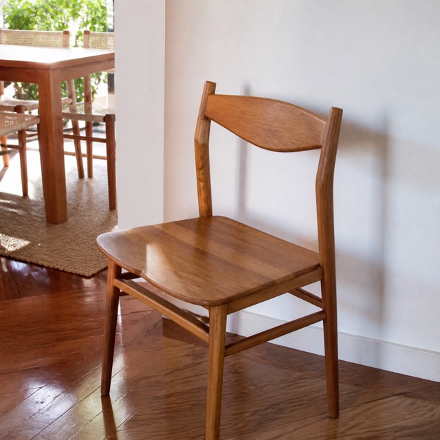 Silla de madera con brillo junto a una pared blanca